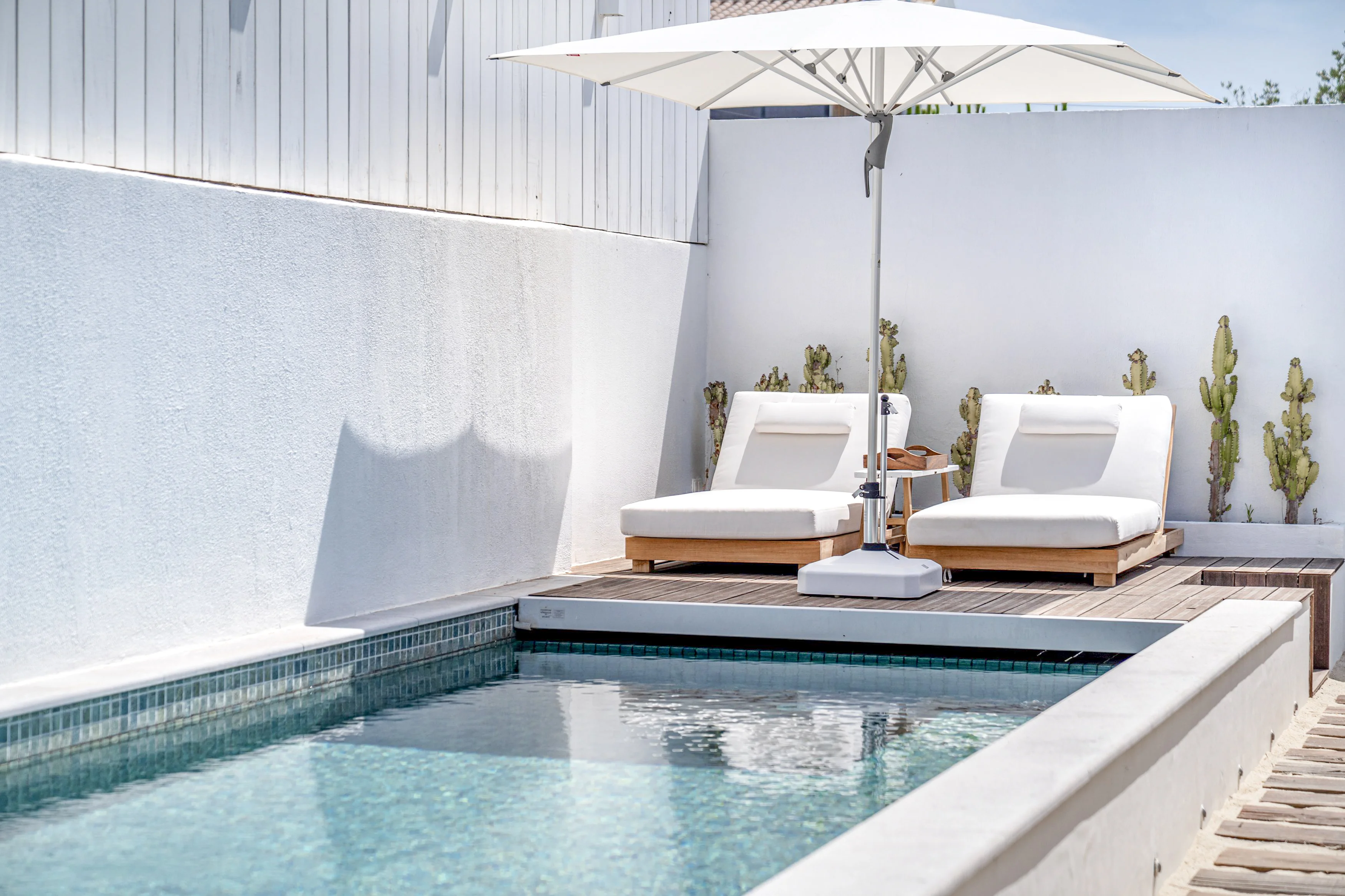 Poolside terrace with plunge pool, sun loungers and cantilever umbrella